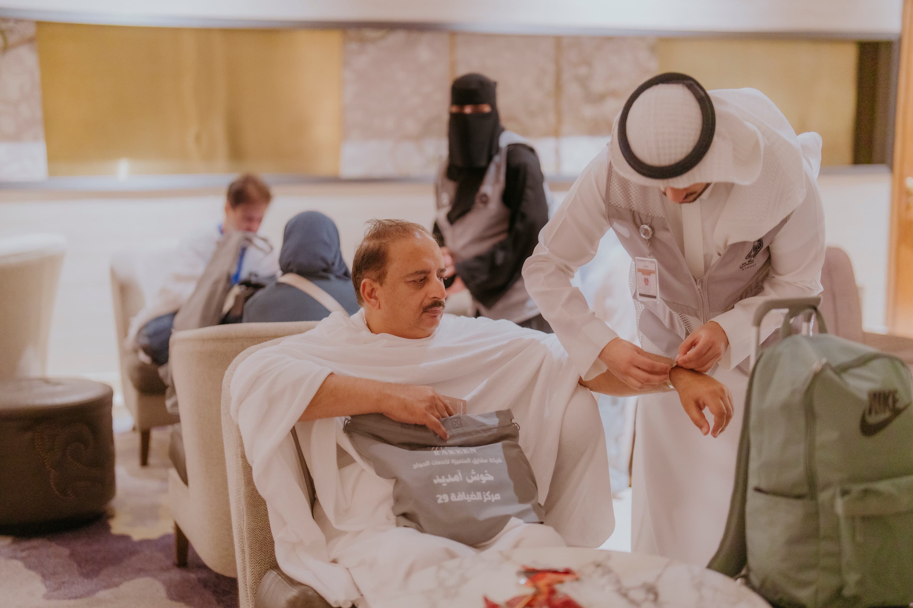 RAQEEN 29 DISTRIBUTING BANDS TO PILGRIMS 